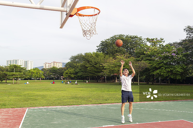 老年篮球运动员向篮筐投球图片素材