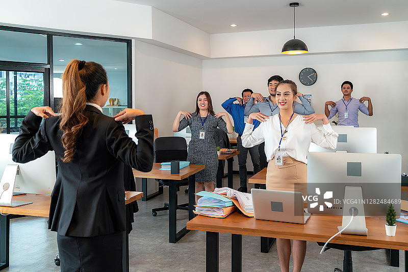 亚洲女商人带领团队在办公室锻炼图片素材