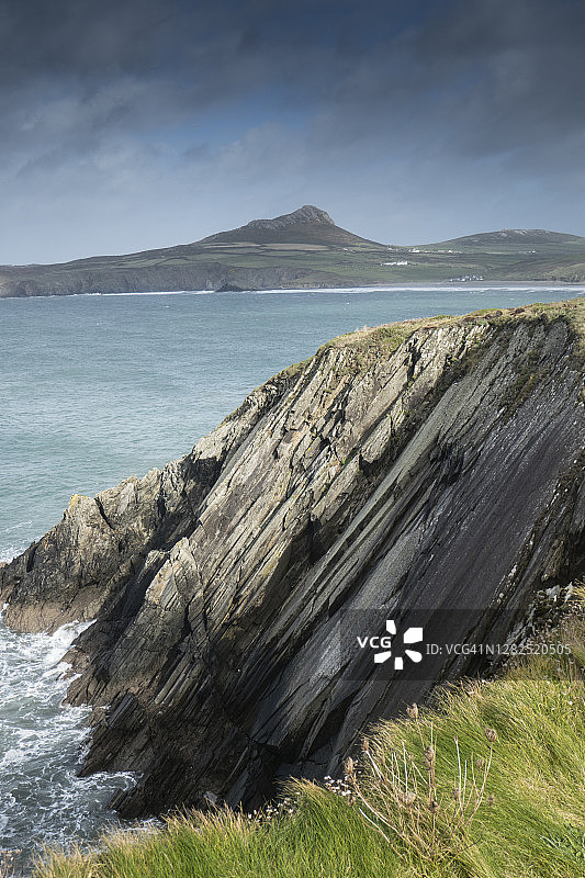 倾斜的岩壁和拉姆齐岛的景色；图片拍摄于彭布罗克郡海岸国家公园的威尔士海岸小径，位于波斯克莱斯和怀特桑兹湾之间，10月图片素材
