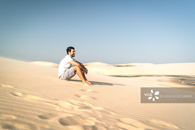 男子坐在杰里科科拉沙丘上欣赏风景图片素材