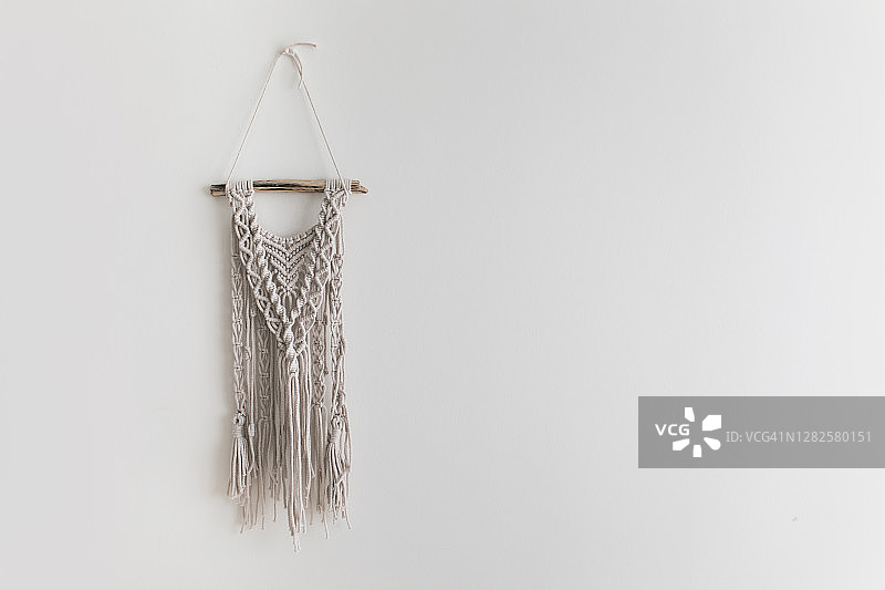 米色墙上手工天然棉质流苏装饰品，时尚环保家居饰品图片素材
