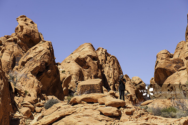 摄影师拍摄美丽沙漠中的岩层图片素材