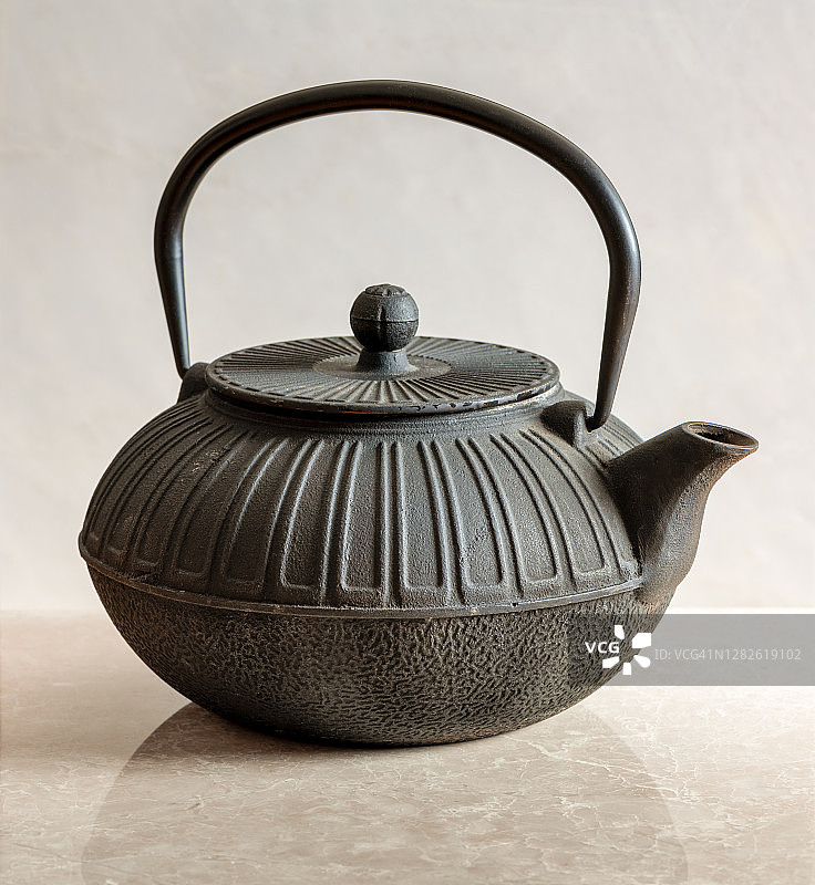 大理石厨房台面上的日式铸铁茶壶图片素材