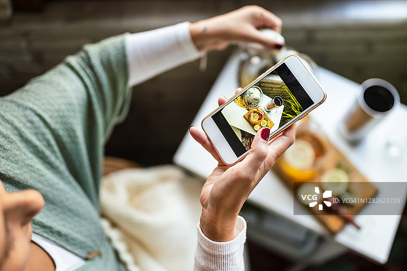 特写：年轻女子在温馨茶馆喝草药茶图片素材