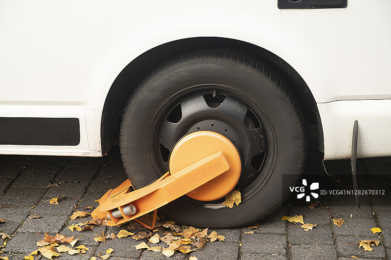 白色车辆车轮，橙色锁具，德国柏林图片素材