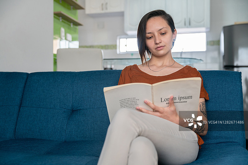 年轻女子在家里看书图片素材