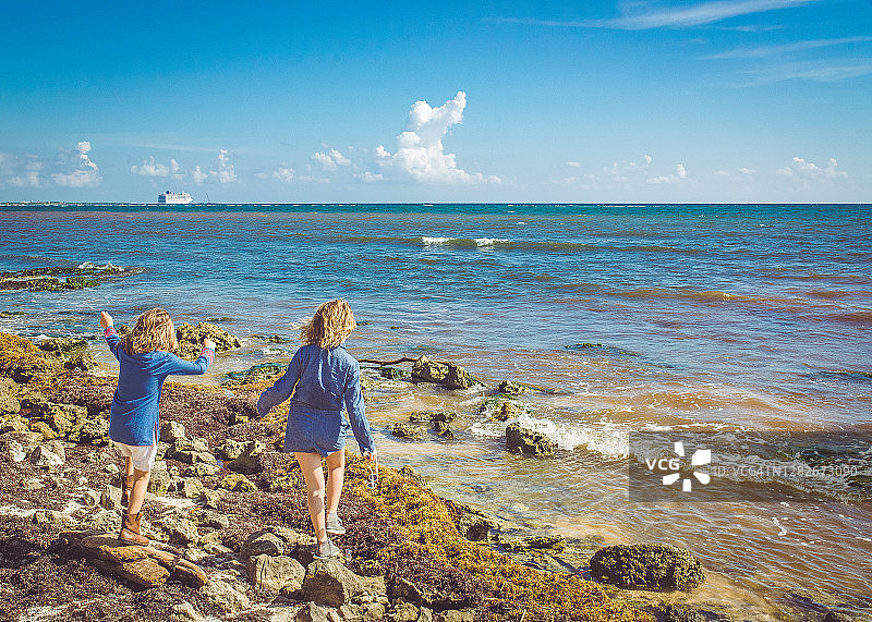 在海滩上探索热带风情游轮的快乐儿童图片素材