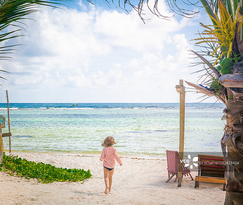 儿童朝着热带田园般的墨西哥海滩跑去图片素材