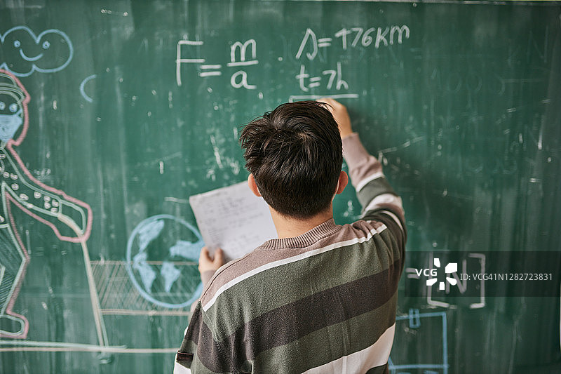 专注的小学生在黑板上解物理题图片素材