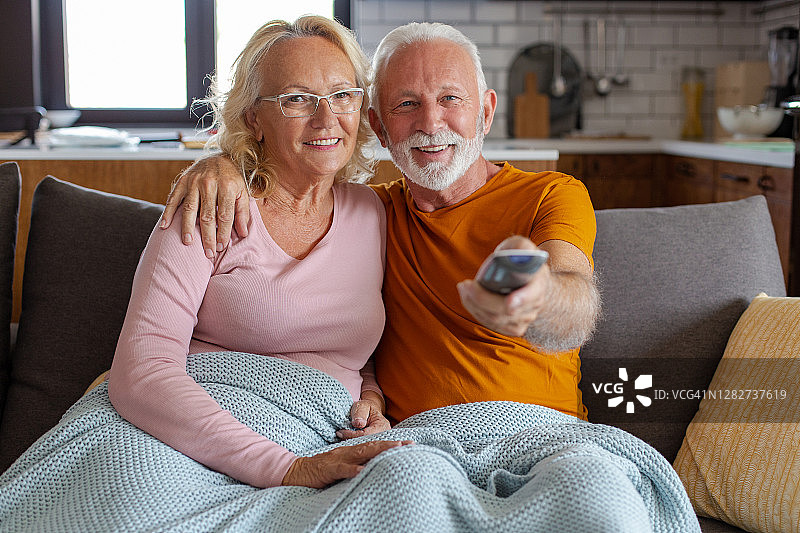 年长夫妇在家里的沙发上看电视放松图片素材