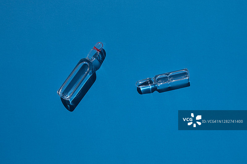 蓝色背景上的疫苗安瓿图片素材