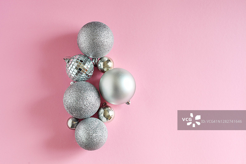粉色背景上的圣诞银色装饰球节日贺卡图片素材