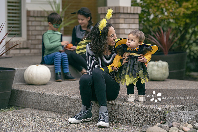 年轻妈妈和宝宝穿着搭配的蜜蜂服装图片素材