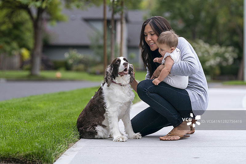 妈妈和宝宝与小狗互动图片素材