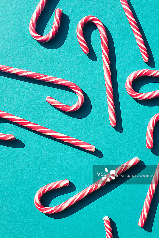 蓝绿色背景上的拐杖糖与硬阴影图片素材