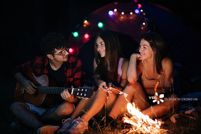朋友们在篝火旁弹吉他露营图片素材