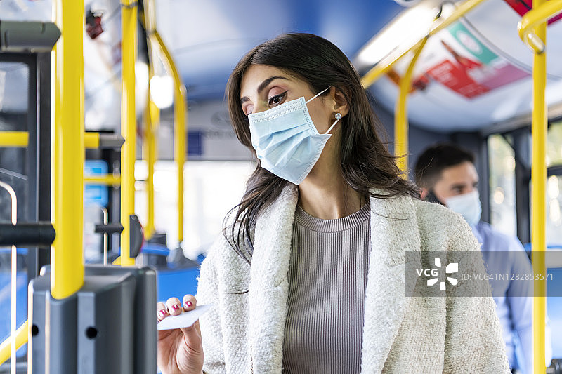 在有轨电车或公共汽车上验票的中年妇女图片素材