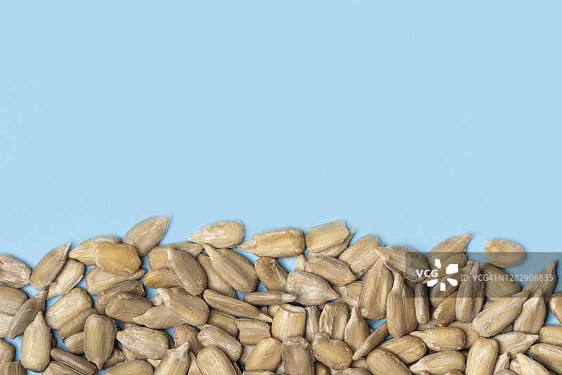 蓝色背景上的去皮葵花籽图片素材