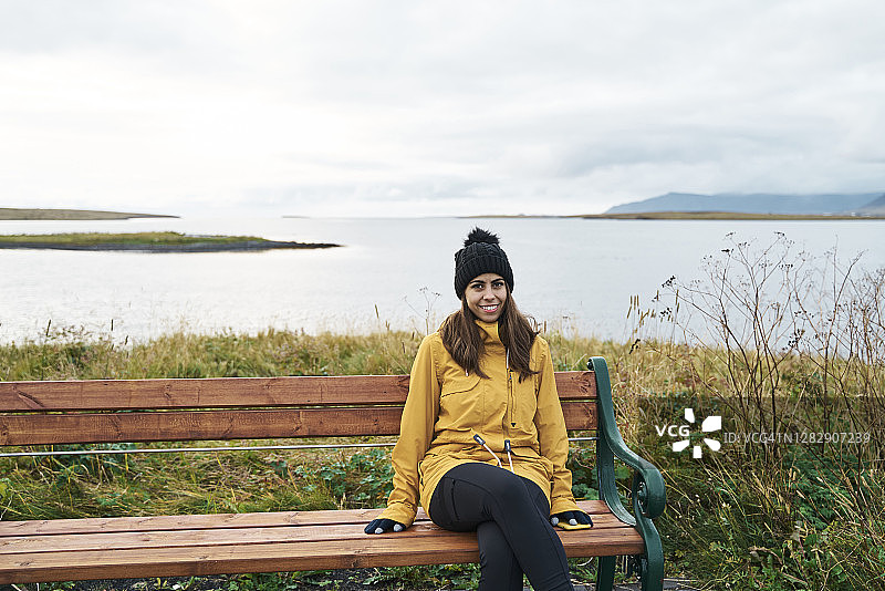 在湖边海滩上放松的乐观年轻少数民族女游客图片素材