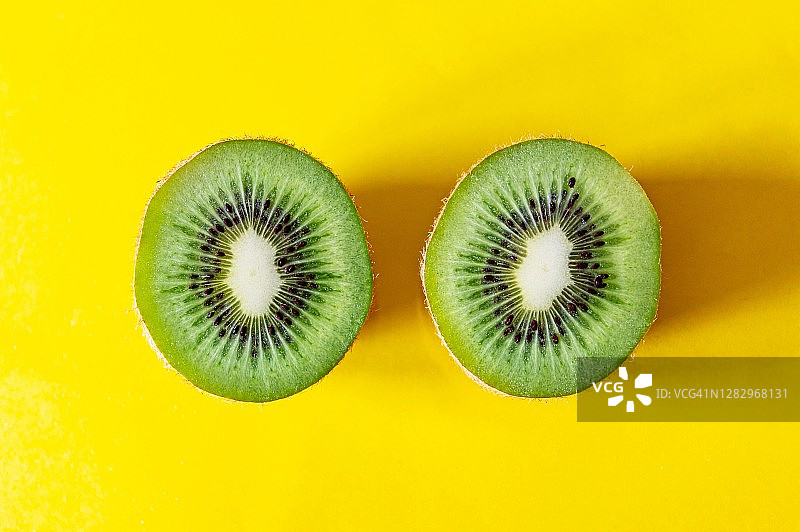 黄色背景上的猕猴桃切块图片素材
