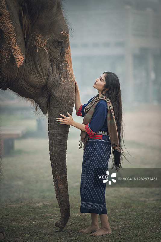 享受与大象互动的年轻泰国女子图片素材