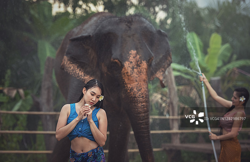 女子在村庄里与大象一起沐浴图片素材