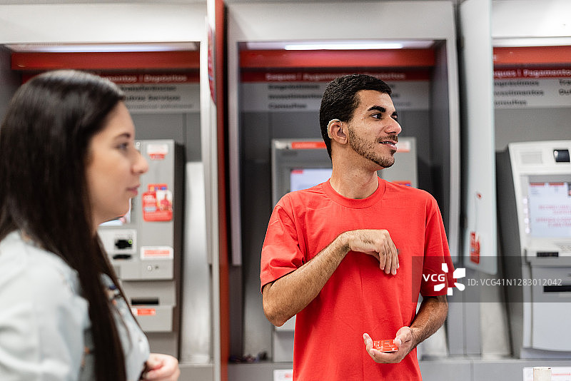 在银行分行使用手语的年轻男子图片素材
