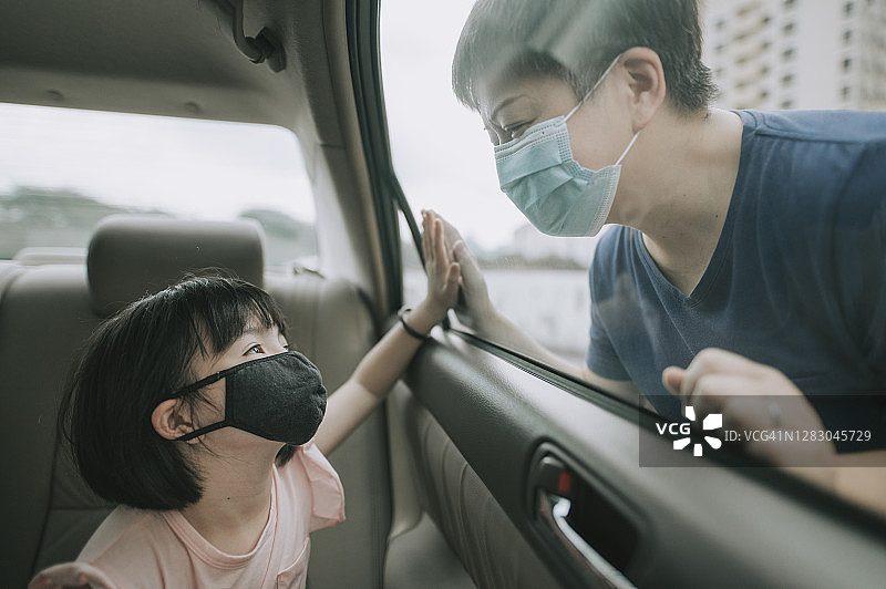 中国女孩在车内隔着窗户开心地看着母亲图片素材