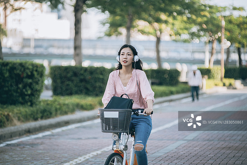 在市中心租用共享自行车的亚洲女性图片素材