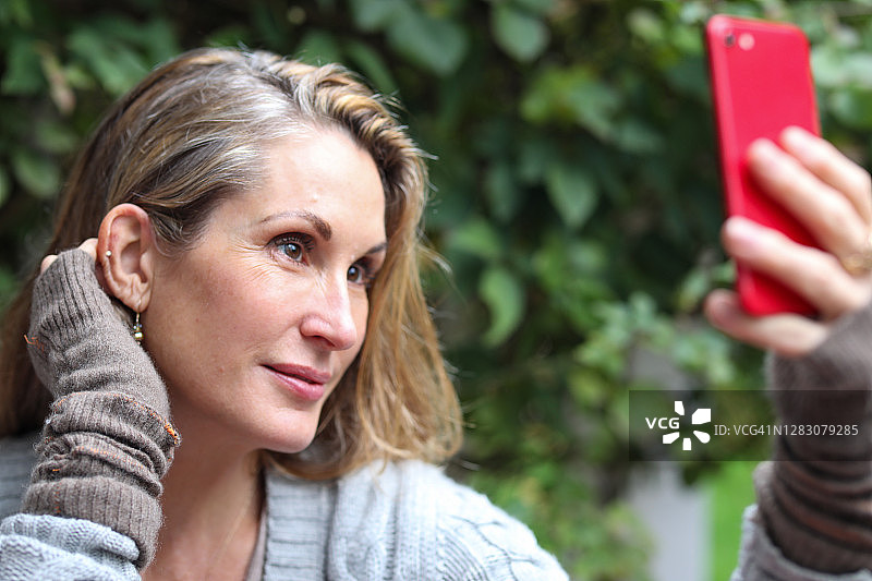 用手机进行视频聊天或自拍的女人图片素材