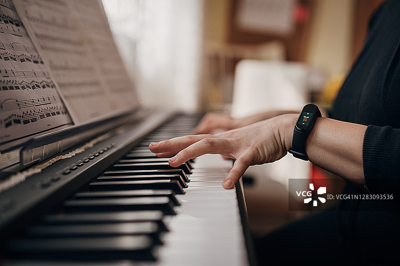 在家弹奏电子琴的女性钢琴家图片素材
