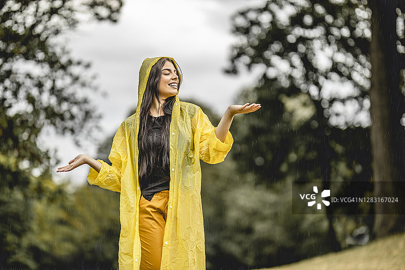 在雨中跳舞的快乐年轻漂亮女人图片素材