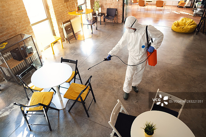 身穿防护服消毒办公室的男人（高角度视角）图片素材
