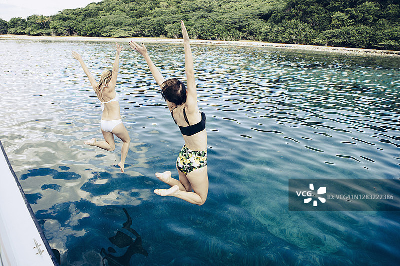 两位年轻女人跳入水中图片素材