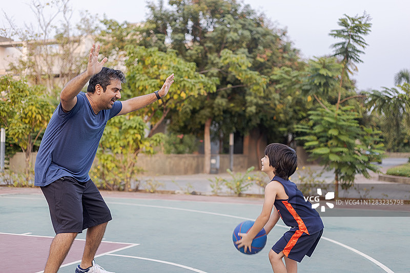 印度男人和儿子一起打篮球图片素材
