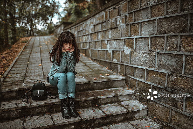 坐在城市公园台阶上的年轻女子图片素材