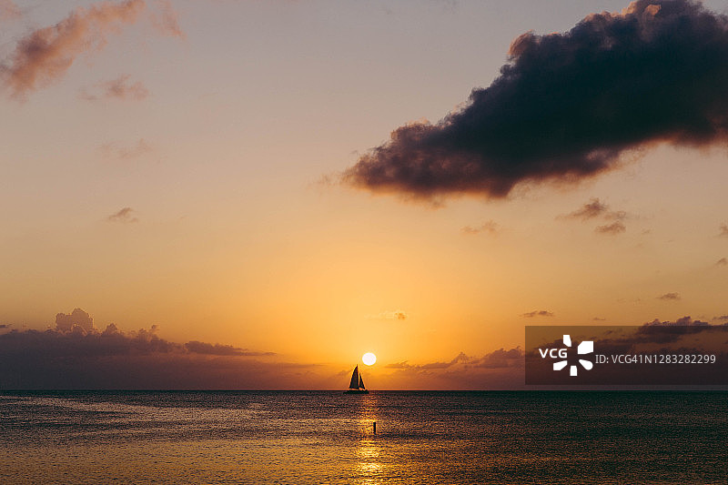 日落时分在地平线上航行的帆船图片素材