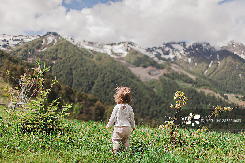 背对着镜头，望着群山的小女孩图片素材