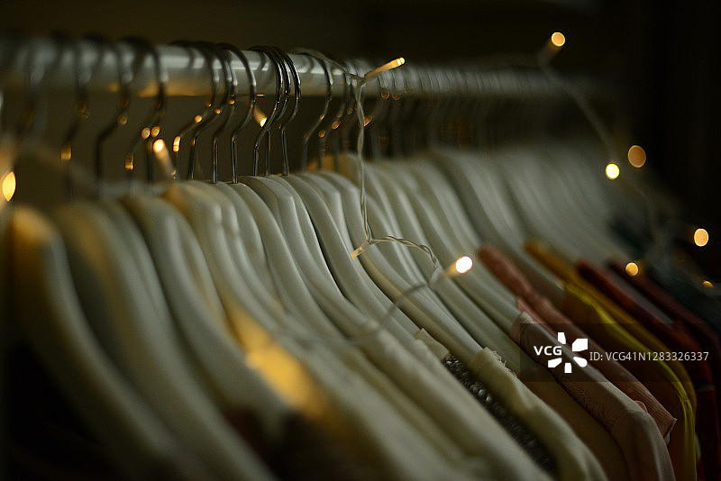按颜色排列挂在衣架上的一排女式衬衫图片素材