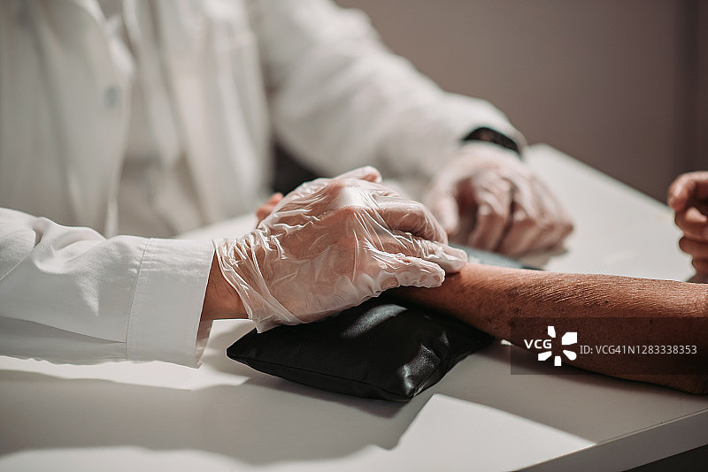 华人男针灸师在中药店为病人进行脉诊图片素材