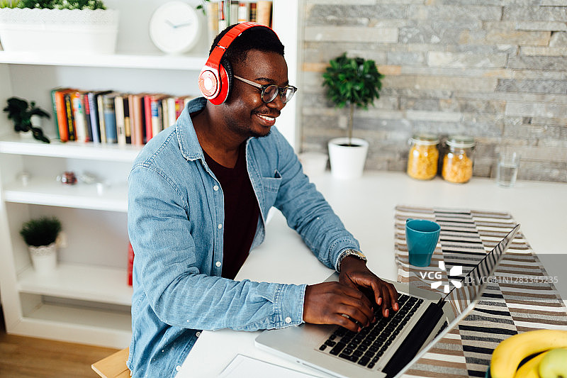 快乐的年轻非裔美国男学生在家工作图片素材