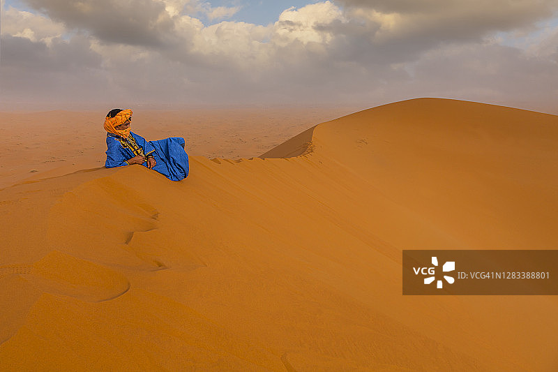 撒哈拉沙漠沙丘上的柏柏尔男人图片素材