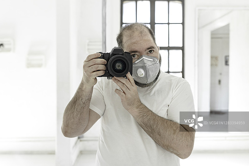 摄影师戴着口罩拍摄抗疫照片图片素材