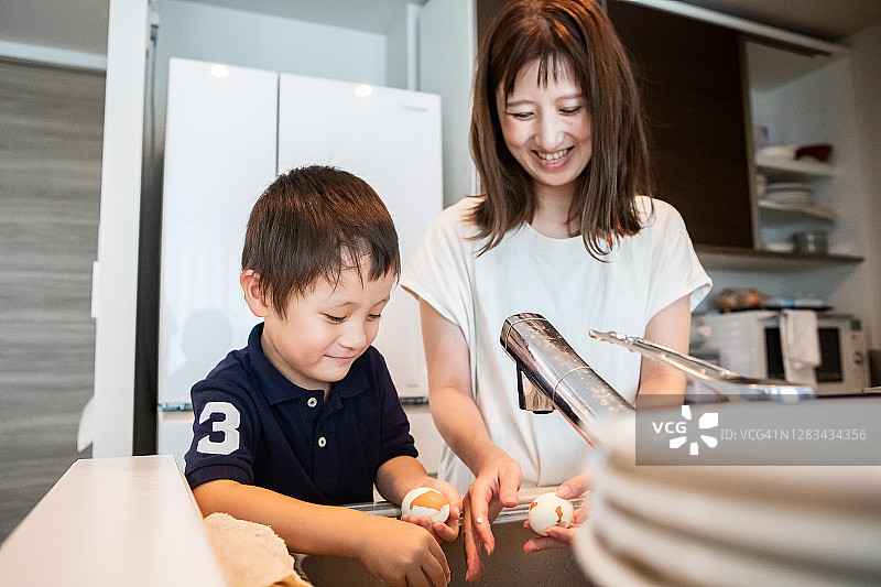 男孩帮妈妈剥鸡蛋图片素材