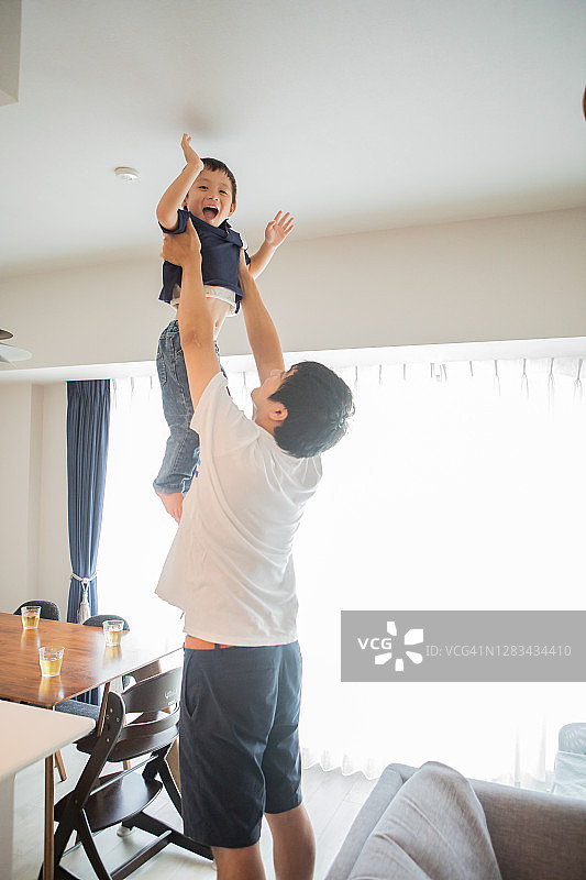 周末男孩在客厅和父亲一起玩耍图片素材