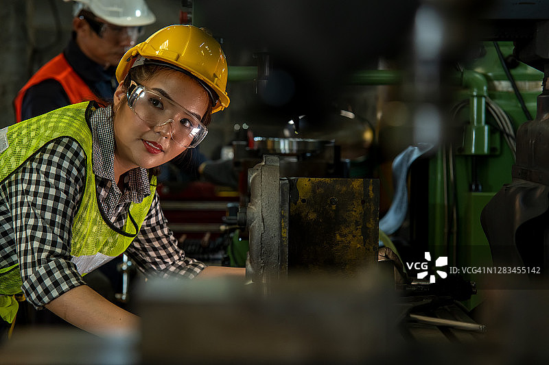 专业女工操作和控制车床钻孔图片素材