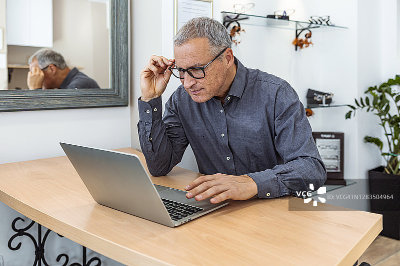 试戴新眼镜的中年男人图片素材