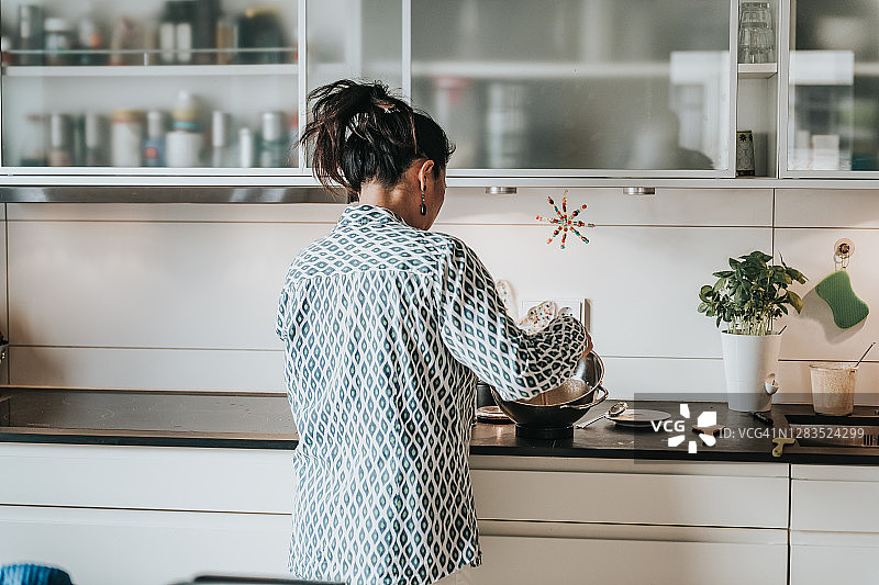 女人在厨房里搅拌自制面包的面团图片素材