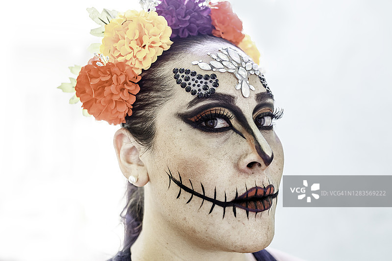 一个画着卡拉维拉妆容庆祝亡灵节的女人图片素材