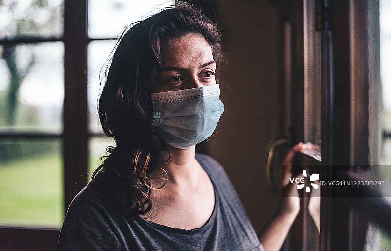 悲伤的女人沉思地望着窗外图片素材